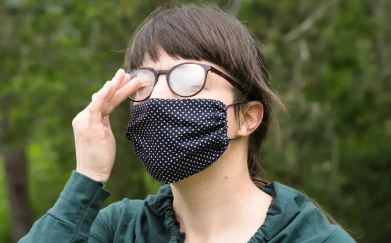 fog appears on a woman's glasses