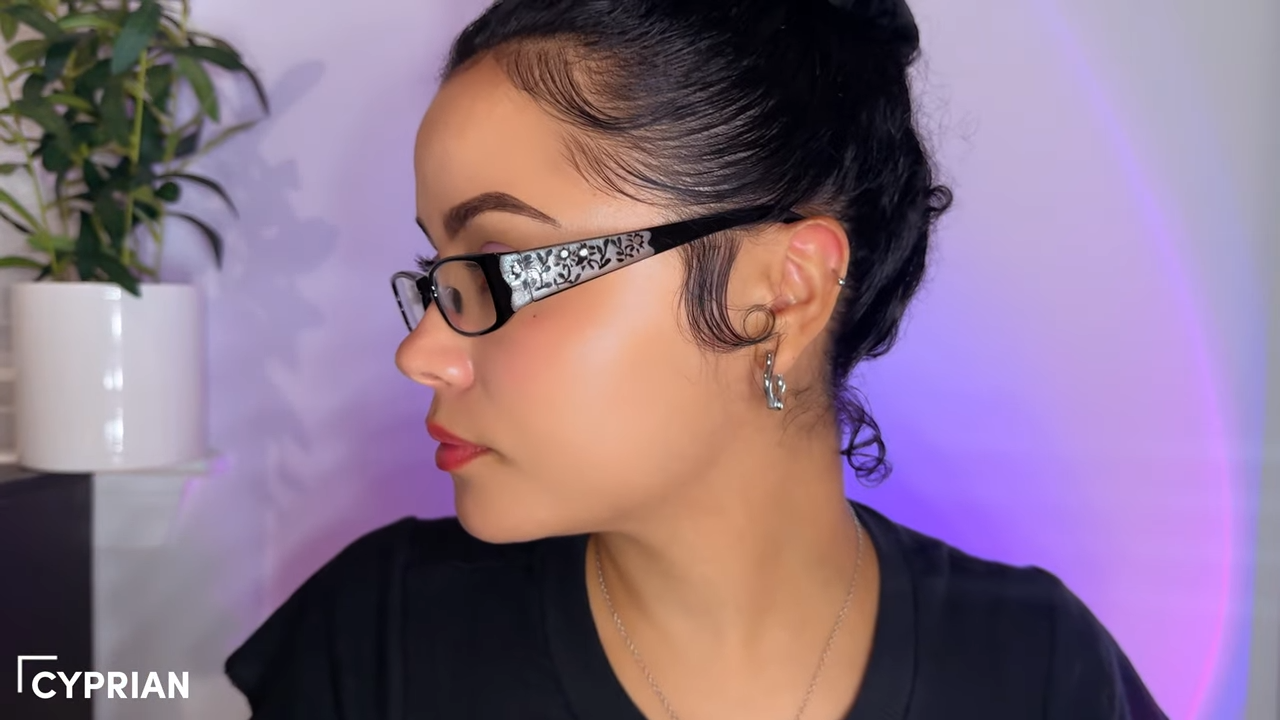 Kirsty Noskcaj wearing stylish black rectangular blue light - blocking glasses with delicate floral detailing and small rhinestones on the sides, as described for Cyprin glasses.