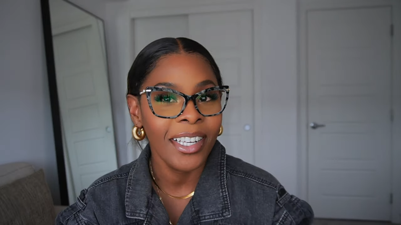 Tara Shanice wearing Lensmart Harriat black tortoise frames with green specks and gold detailing, showing office - ready sophistication.