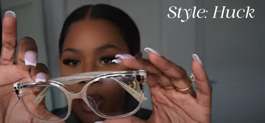Tara Shanice holding Lensmart Huck frames, a funky nude/pinkish tortoise - patterned pair with blue light protection.