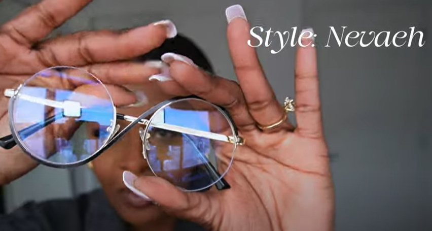 Tara Shanice holding Lensmart Nevaeh frames, featuring a gold double - bridge, black accents, and a Harry Potter - esque silhouette.