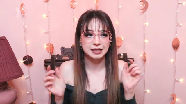 Zoe wearing Jasmine delicate pair with dangles, featuring irregularly shaped metal frames with rhinestone-studded dangles on the arms, in a pink and gold combination, prescription is right.