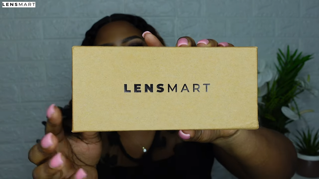 Mimi Manaso holding up the brown Lensmart box to the camera, as she begins to unbox the package for her review.