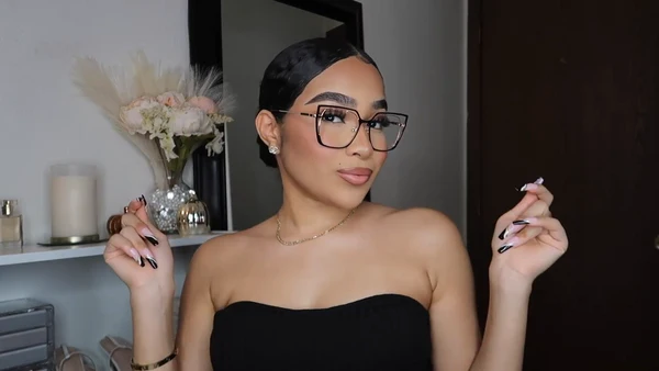 Symphony Taylor wearing Lensmart Yandi glasses, highlighting their black - gold contrast, geometric shape, adjustable nose pads, and versatile gold hues.